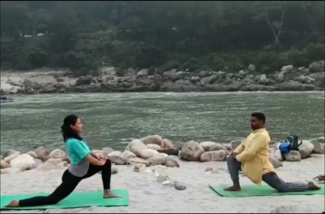 María Eugenia practicando yoga junto al Ganges con un profesor
