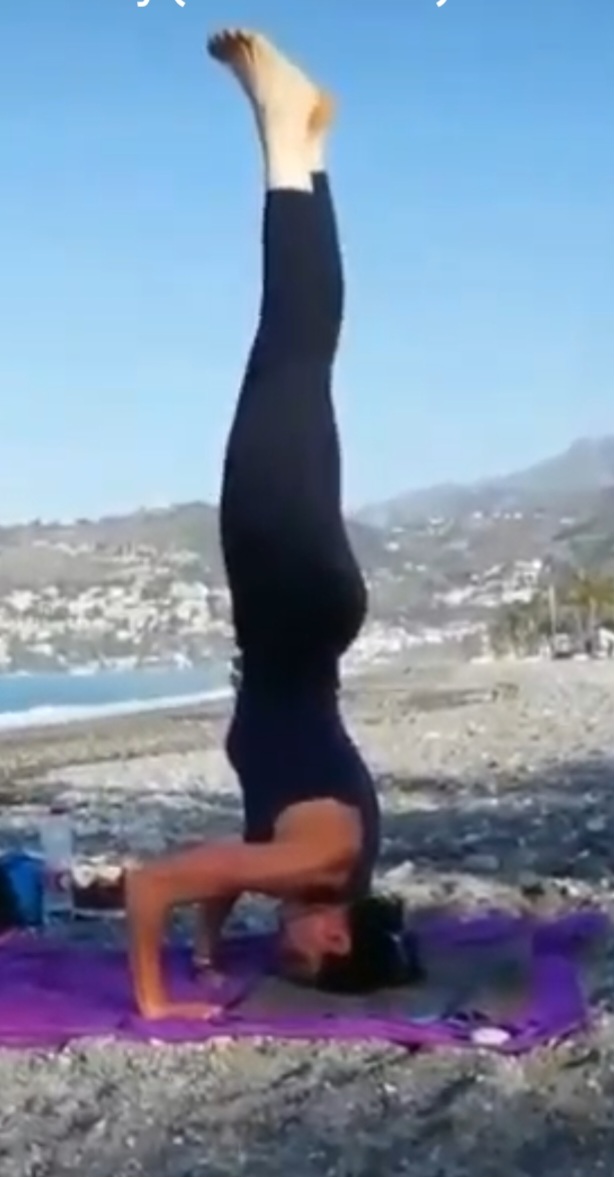 María Eugenia en una postura invertida frente a la costa